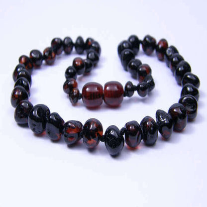 Two amber necklaces with black and red beads on a white background