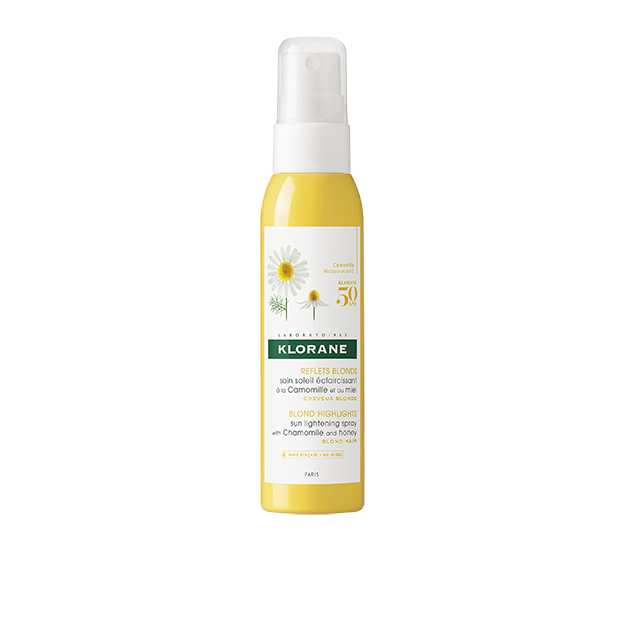 A bottle of Klorane hair treatment with a yellow label and a white spray nozzle, indicating it is a hair care product.