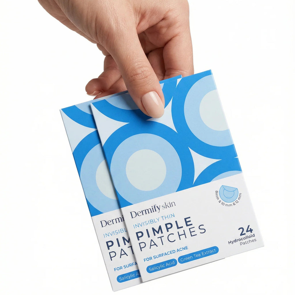 Hand holding a package of Dermika pimple patches on a white background