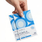 Hand holding a package of Dermika pimple patches on a white background