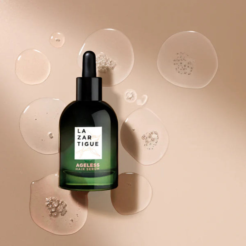 Bottle of La Zar Tigue Ageless Face Serum on a beige background with droplets.